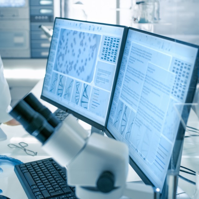 Computer monitors with scientific results and a microscope